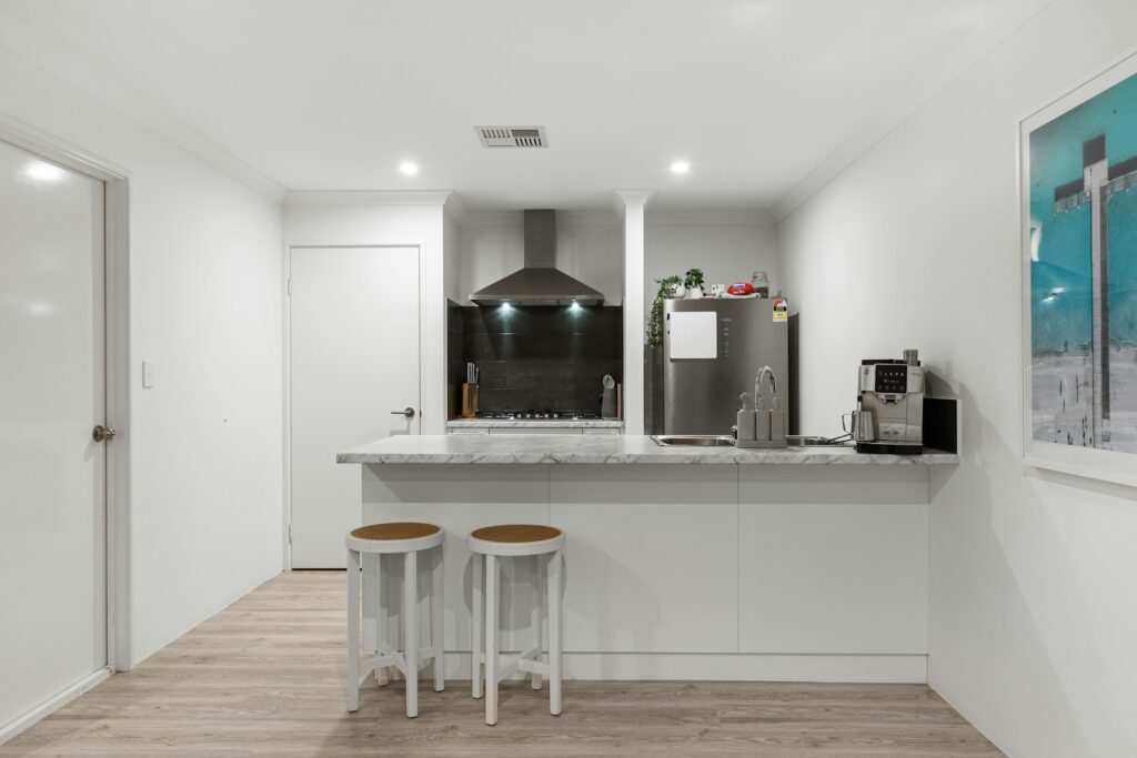 A kitchen with white walls and wooden floors
